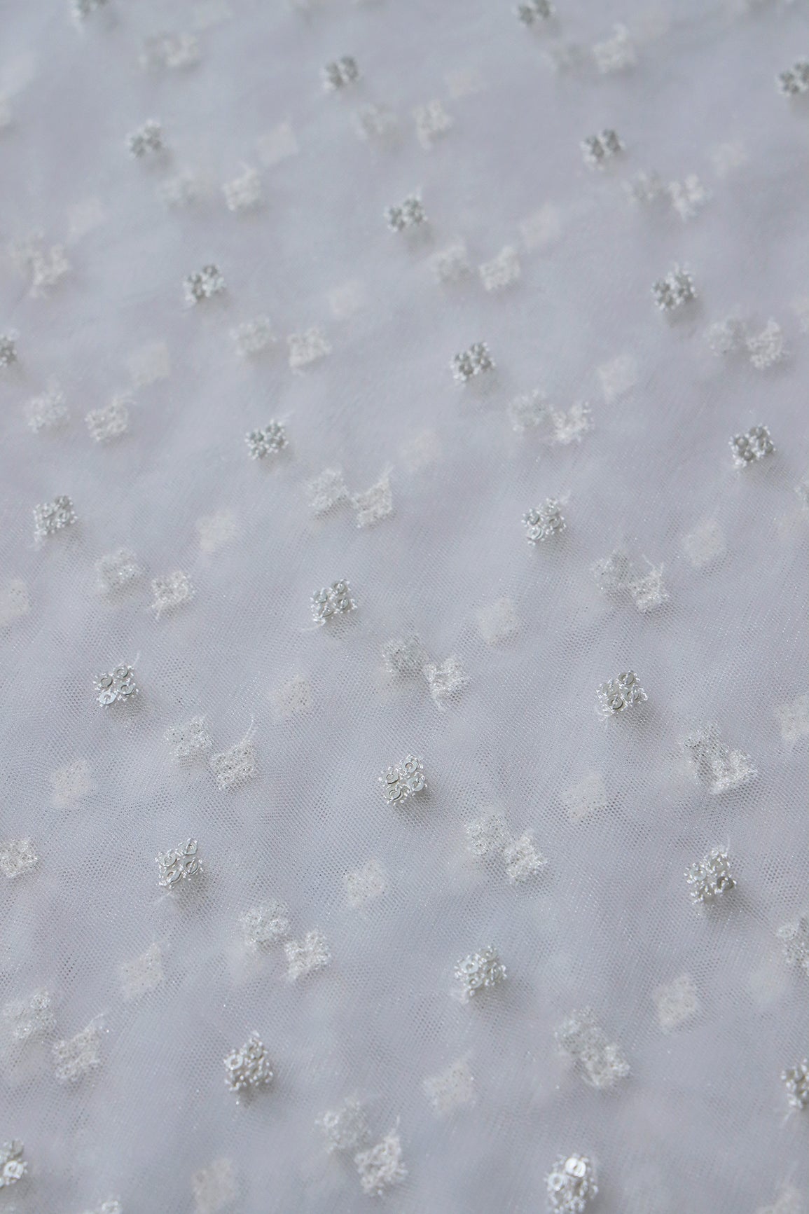 Small Motif Sequins Embroidery Work On White Dyeable Soft Net Fabric