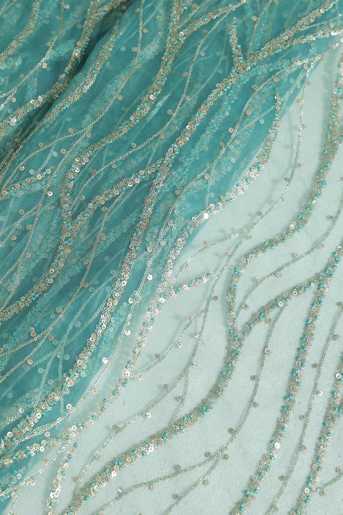 Gold And Silver Sequins With Teal Thread Wavy Embroidery Work On Teal Soft Net Fabric