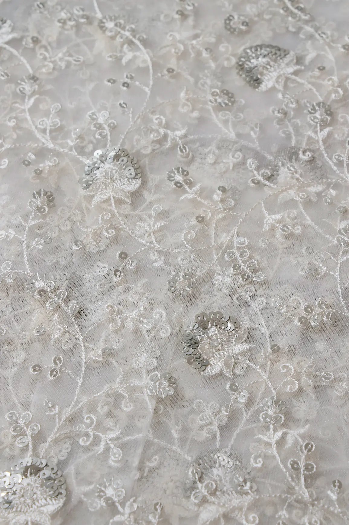 White Thread With Silver Sequins Floral Embroidery On White Dyeable Soft Net Fabric