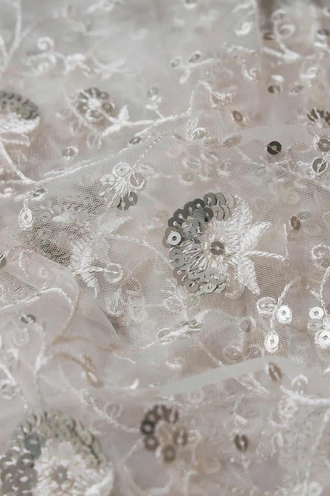 White Thread With Silver Sequins Floral Embroidery On White Dyeable Soft Net Fabric