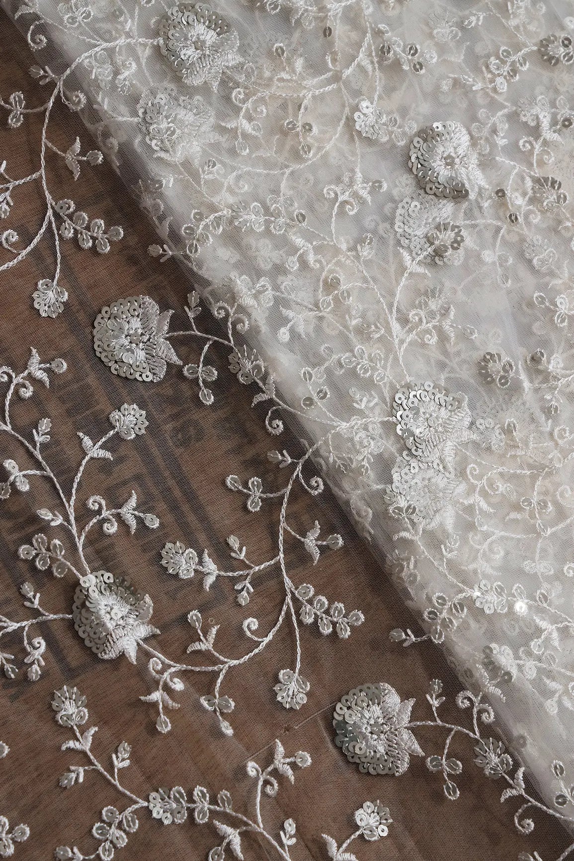 White Thread With Silver Sequins Floral Embroidery On White Dyeable Soft Net Fabric