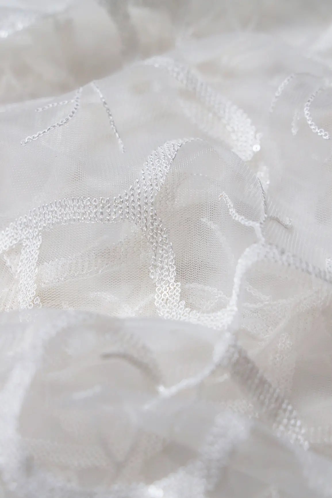 White Sequins Abstract Embroidery On White Dyeable Soft Net Fabric