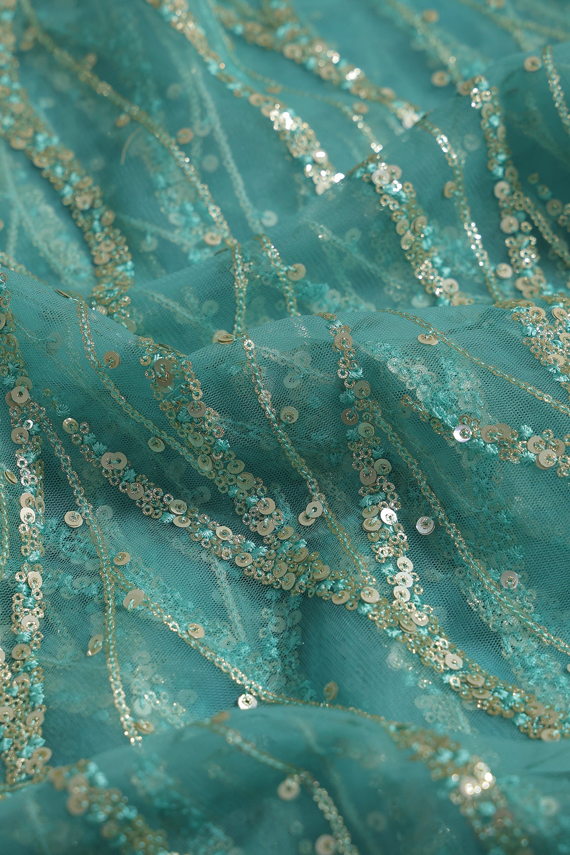Gold And Silver Sequins With Teal Thread Wavy Embroidery Work On Teal Soft Net Fabric