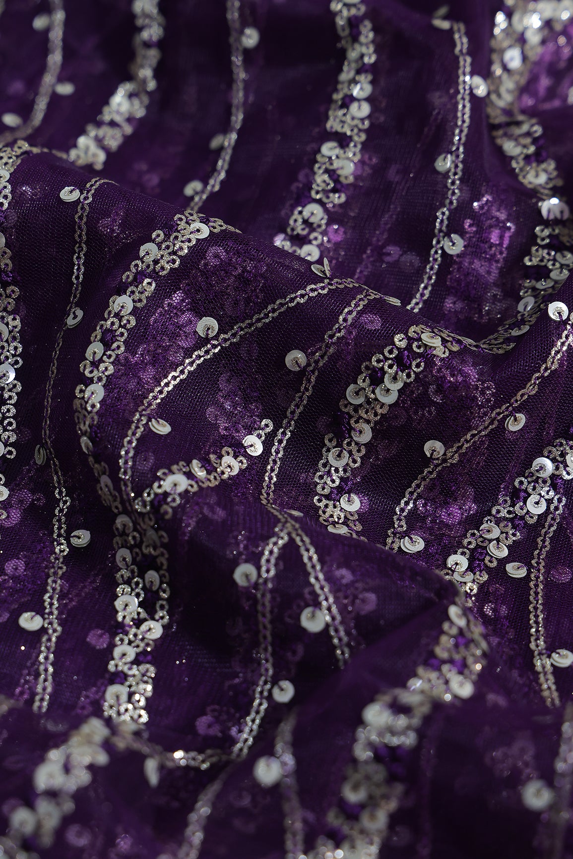Gold And Silver Sequins With Purple Thread Wavy Embroidery Work On Purple Soft Net Fabric
