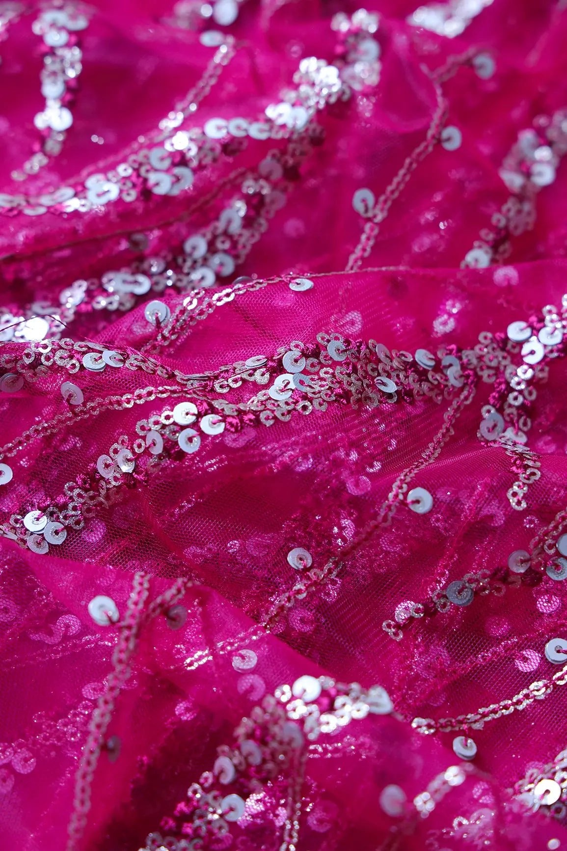 Gold And Silver Sequins With Fuchsia Thread Wavy Embroidery Work On Fuchsia Soft Net Fabric - doeraa