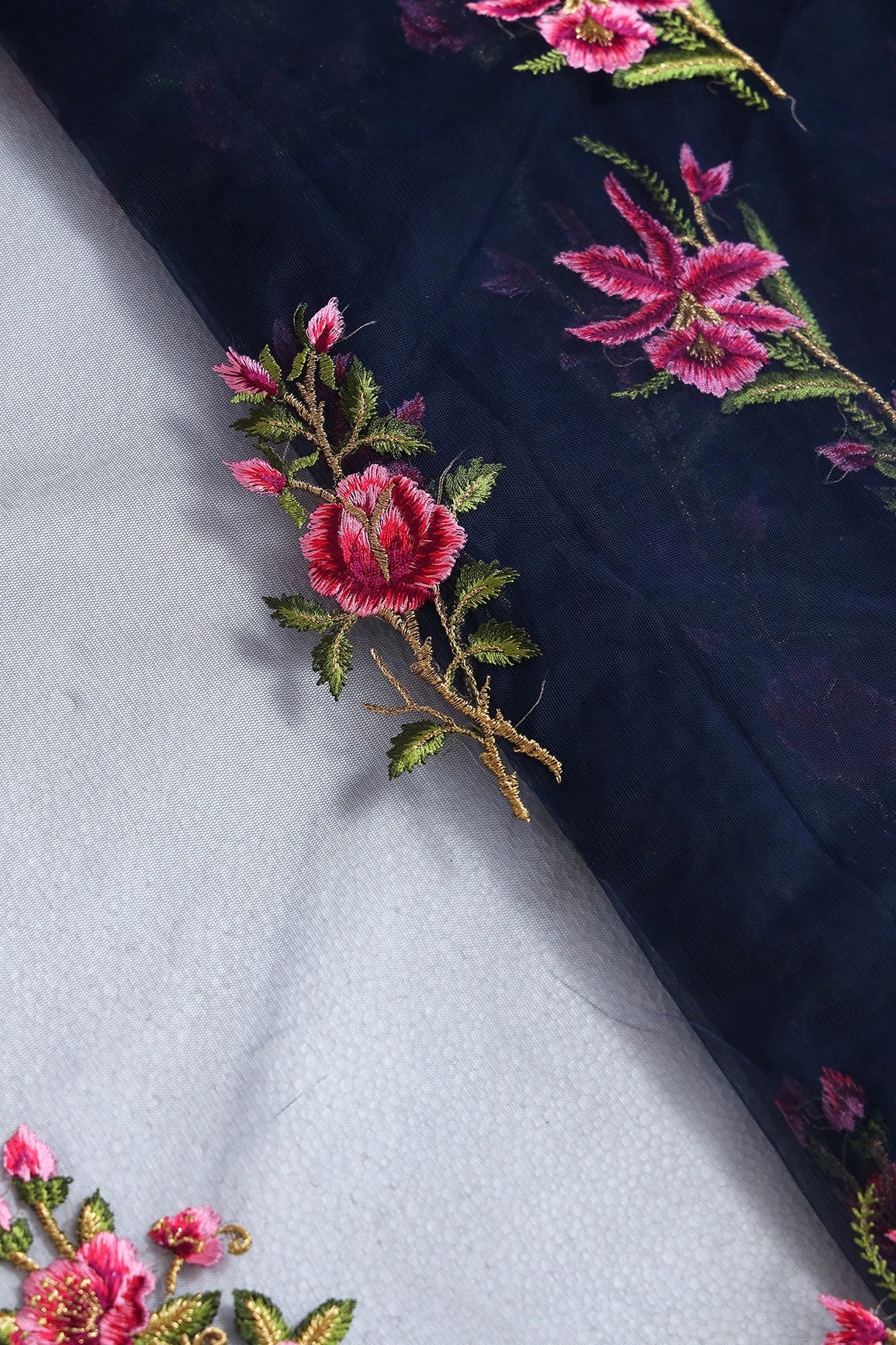 Pink And Olive Thread With Gold Zari Floral Embroidery On Navy Blue Soft Net Fabric - doeraa